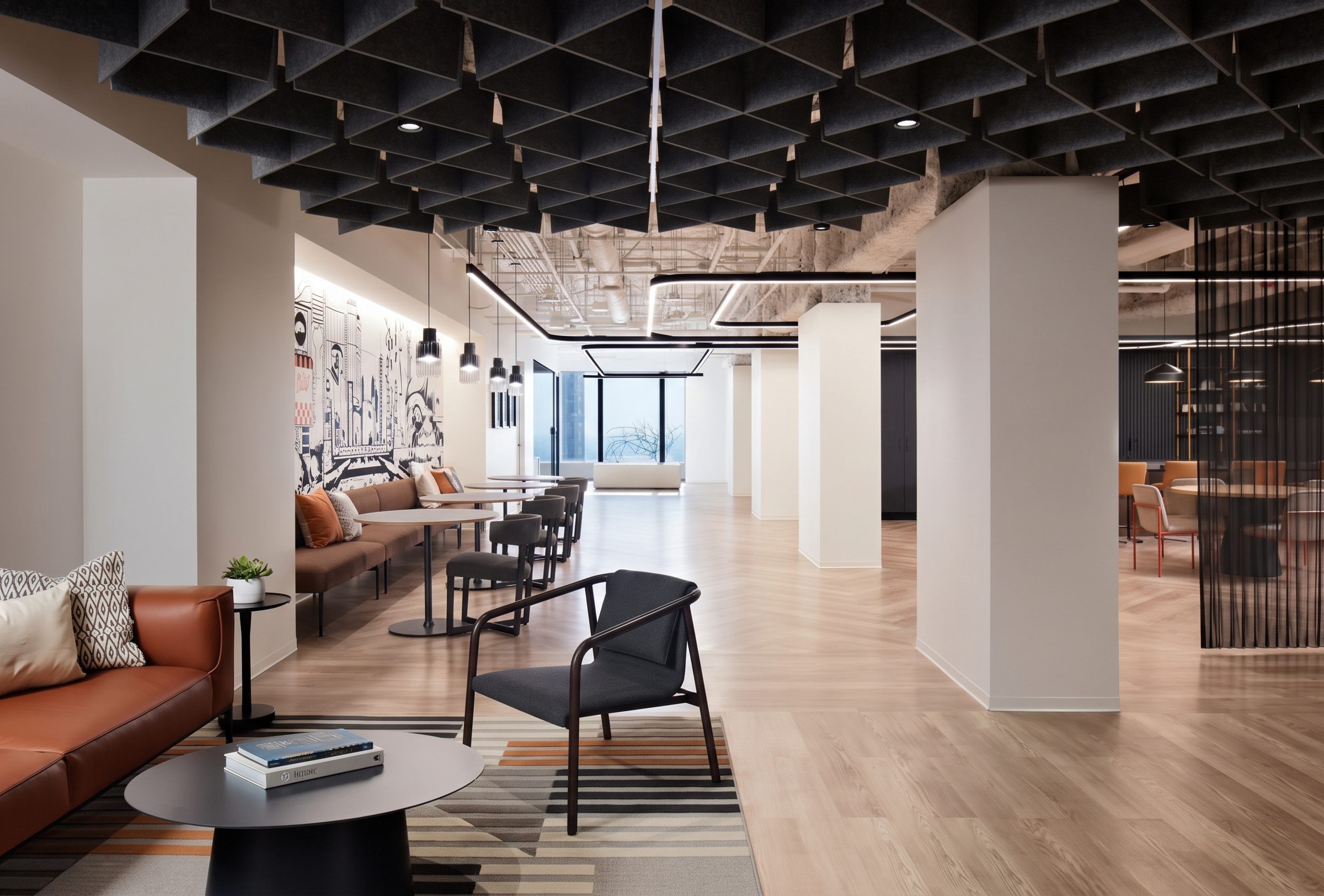 Oficina remodelada con plafón acústico, columnas blancas, piso de madera y sala con sillón de piel